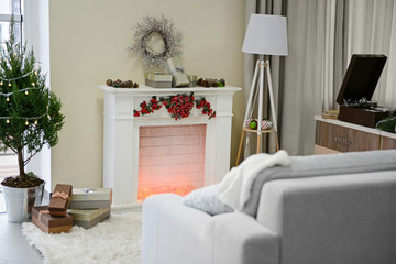 Christmas decorated room with fireplace and fir tree