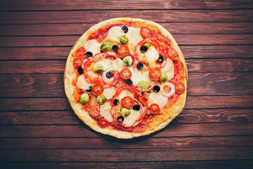Delicious pizza with cheese and vegetables on wooden background