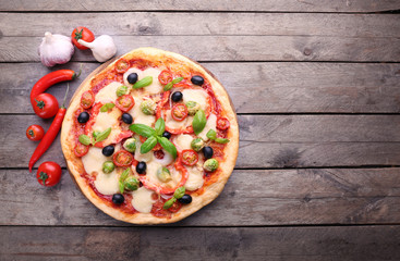 Delicious pizza with cheese and vegetables on wooden background