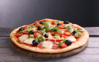 Delicious pizza with cheese and vegetables on grey background