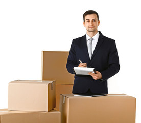 Delivery concept. Man in black suit with carton boxes isolated on white background