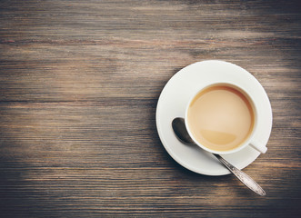 Porcelain cup of tea with milk on wooden background