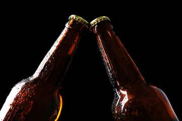 Two glass bottles of beer on black background