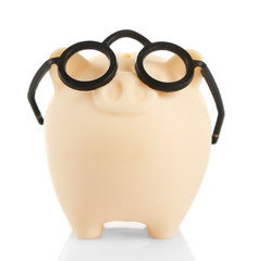 Piggy bank in glasses isolated on white