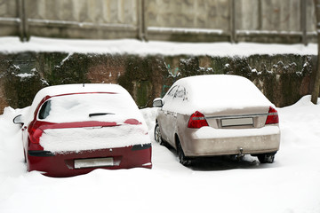 Cars covered with snow beside the building