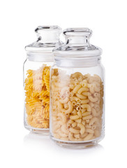 Raw macaronies in a glass jar on a white background