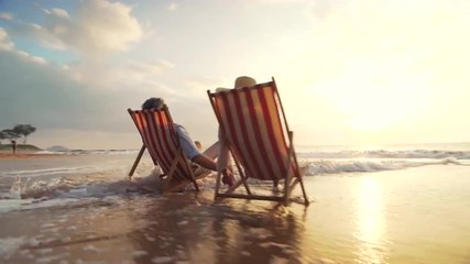 4K Retirement Vacation Concept, Happy Mature Retired Couple Enjoying Beautiful Sunset at the Beach - Powered by Adobe