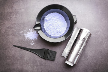 Barber set with hair dye, foil and brush on grey background