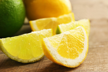 Sliced fresh lemon and lime on wooden table closeup