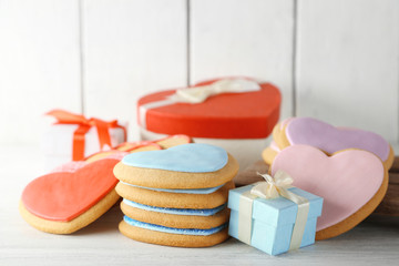 Valentine heart cookies with present boxes on wooden background