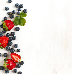 Fresh strawberries and blueberries on wooden background