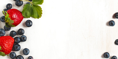 Fresh strawberries and blueberries on wooden background