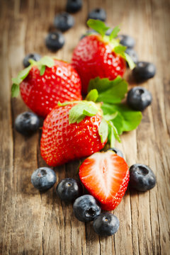 Fresh strawberries and blueberries on wooden background