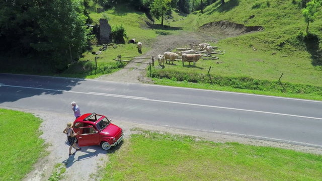 An older couple parks its car at the side of the road