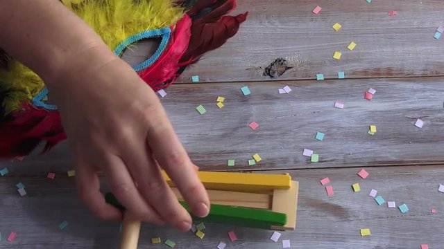 Woman hand flat lay Purim Jewish holiday food and objects:  carnival mask wooden Purim gragger and Hamantaschen. Copy text space.