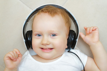 the little boy listens to music in big headphones