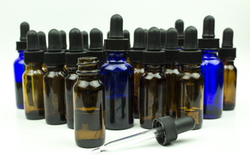 Group of dropper bottles of different colors and sizes with focus on the foremost