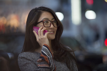 Young women are over the phone outside