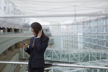 Business women who are using a smart phone in the modern building