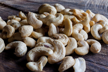 Cashew nuts on wooden cutting board background from side