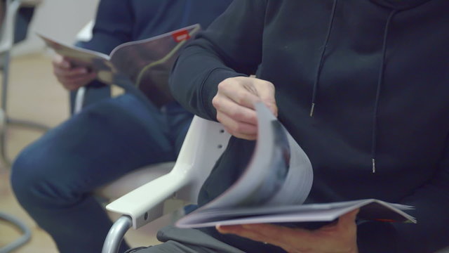 People are flipping through a brochure