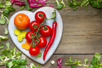 Fresh spring vegetables on wooden heart health lifestyle diet concept
