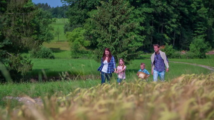 Family is walking on countryside near wheat field