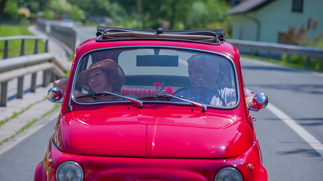 Senior couple enjoying the conversation in a red zastava car