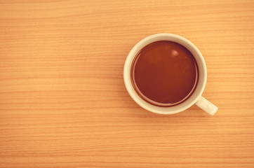 Coffee cup on wood table,top view.