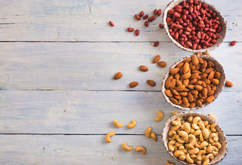 Bowls of shelled peanuts almonds and cashew above