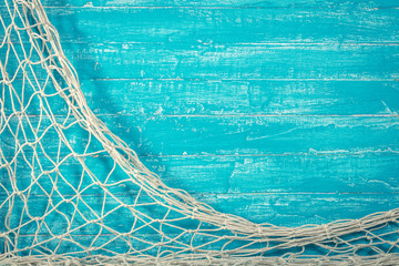 Fishing net on old blue board - obrazy, fototapety, plakaty