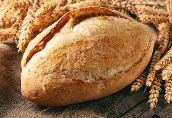 loaf of homemade bread with ears of wheat