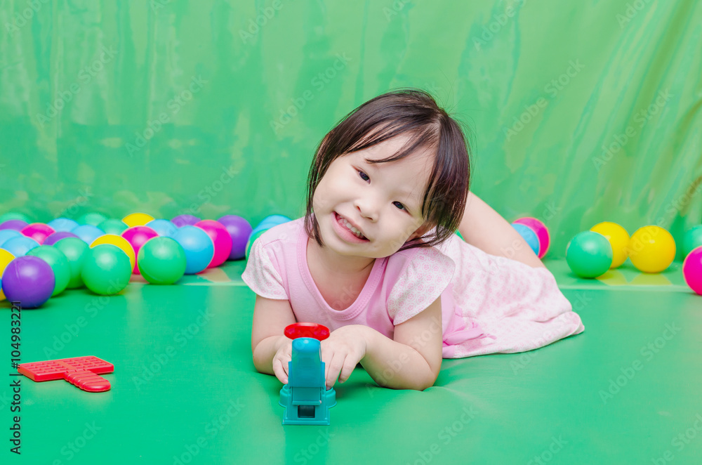 Wall mural Little Asian girl playing toy at school