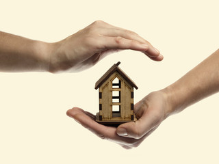 Isolated toned image of hands that protect the small house