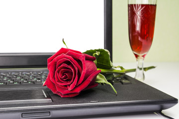 Rose and wine on a laptop keyboard