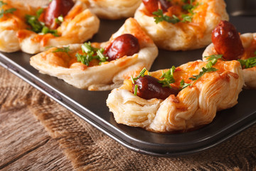 snack puff buns with sausage, cheese and onion macro in baking dish. 
