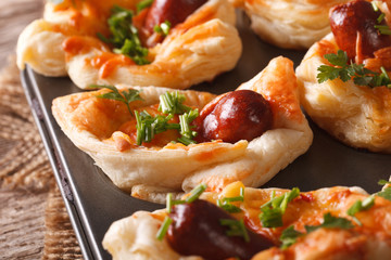 puff buns with sausage, cheese and onion macro in baking dish. horizontal
