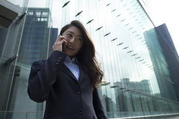 Business woman make a phone call in front of the building