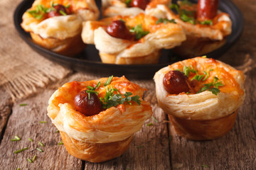 buns of puff pastry with sausage and cheese close-up. Horizontal
