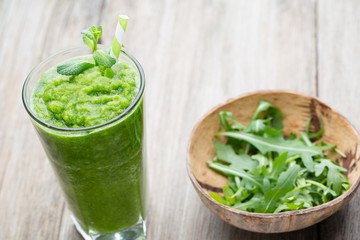 Rucola smoothie, on the grey  background.