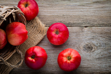 Ripe red apples on wooden background.