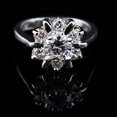 Luxury jewellery. White gold or silver ring with diamonds closeup. Selective focus.