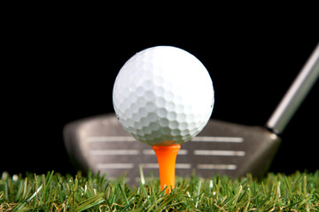 Golf club ready to hit golf ball on black background