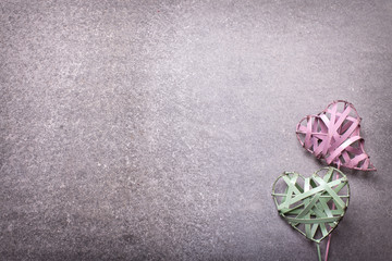 Two  green and pink decorative  hearts on  grey slate  backgroun