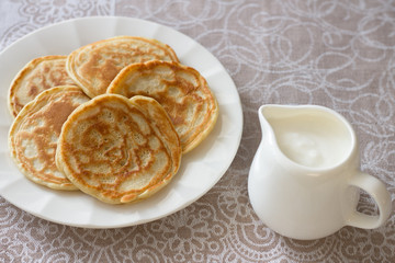 Freshly baked pancakes with sour cream on a textile tablecloths