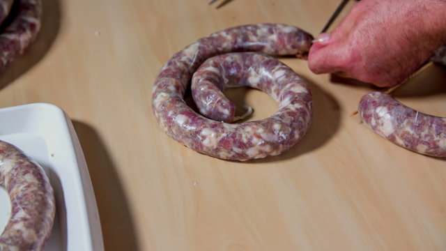 Cutting extra intestine off sausage