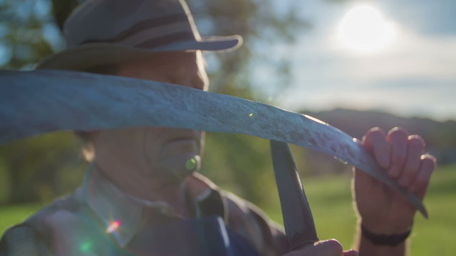 Scythe being sharpen with a grinder on traditional way