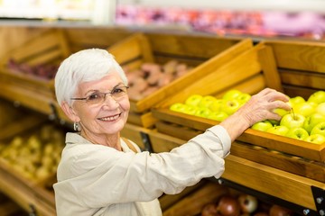 Senior woman picking out a green apple