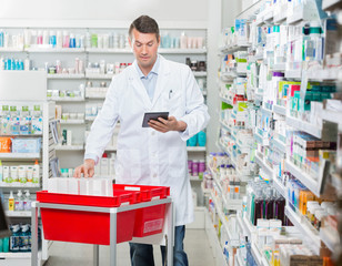 Pharmacist Counting Stock While Using Digital Tablet