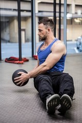 Muscular man training with exercise ball